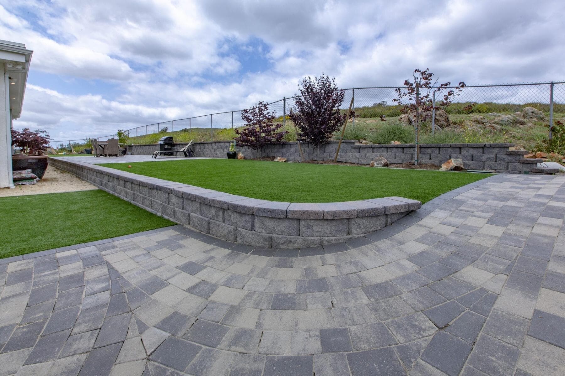Paver walk wrapping a turf terrace and block retaining wall at Dictionary Hill