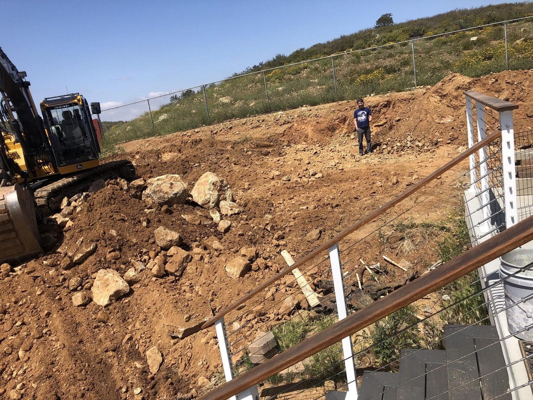 Skid steer cutting and moving dirt on the hillside