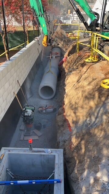 RCP storm drain pipe being set in a trench in El Cajon