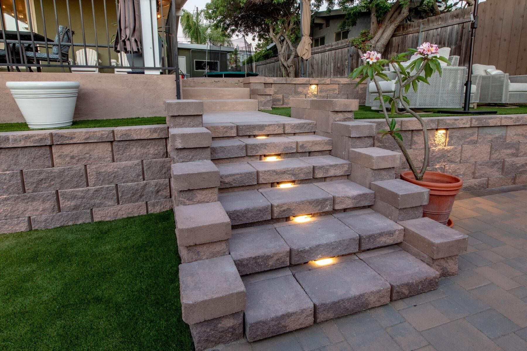 Block stairs with step lights, turf, and pavers in La Mesa