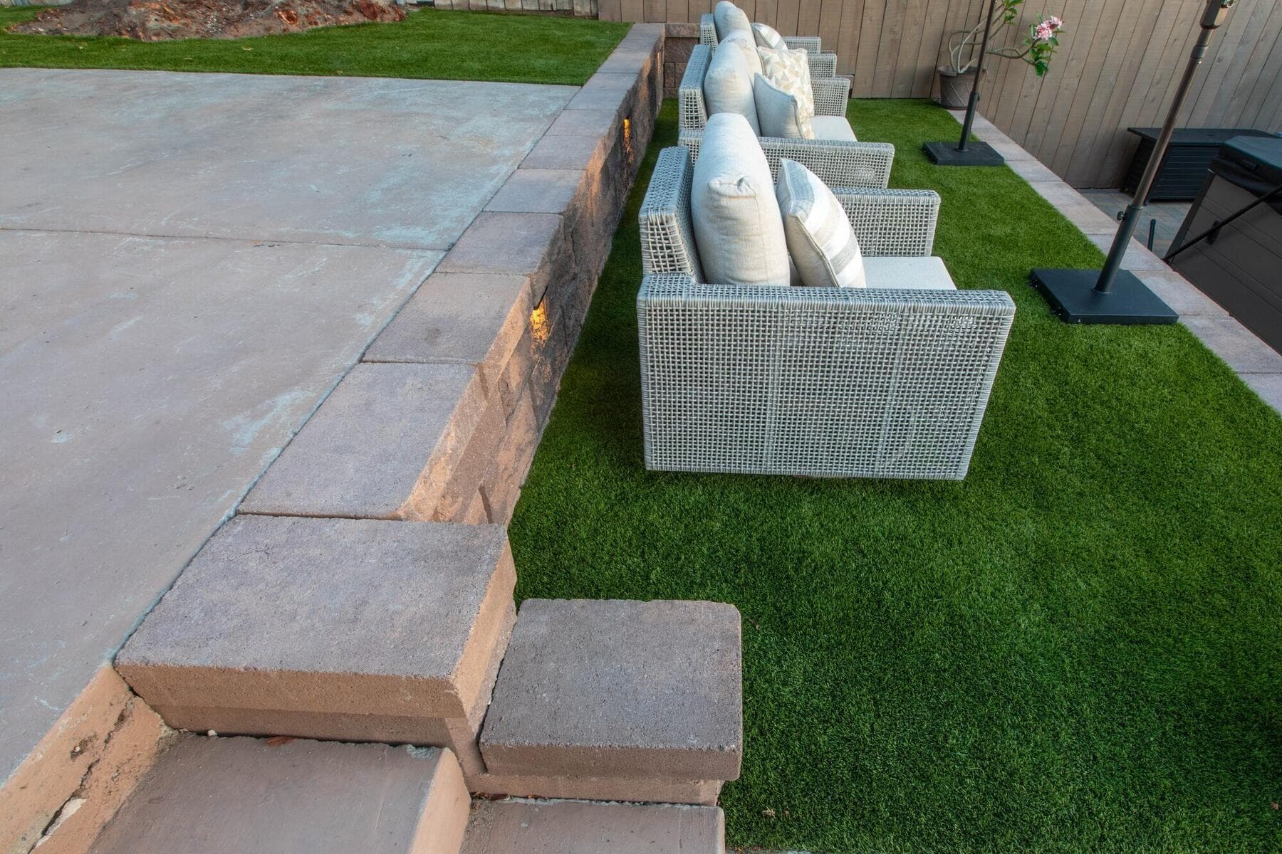 Block wall, turf, and outdoor sofa on the upper terrace