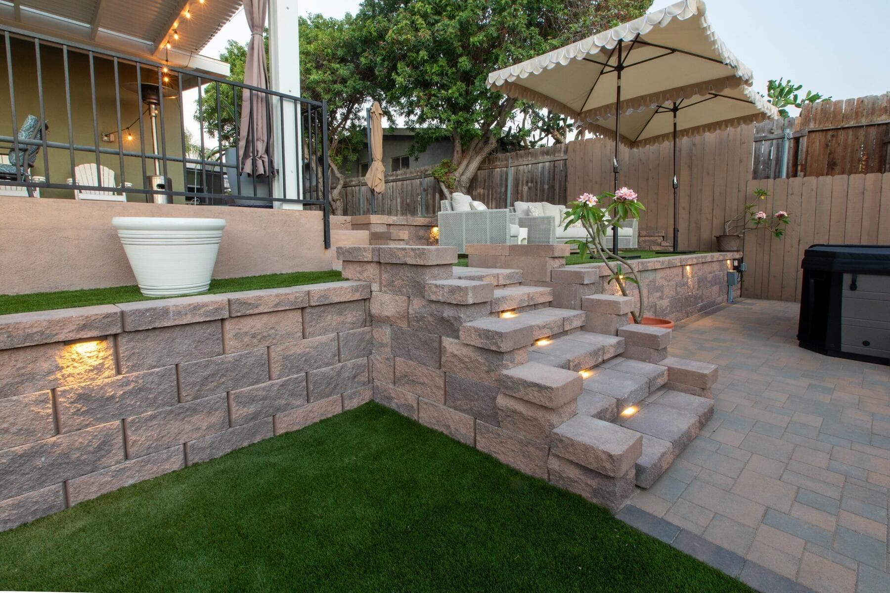 Corner block stairs connecting the upper terrace to the paver patio