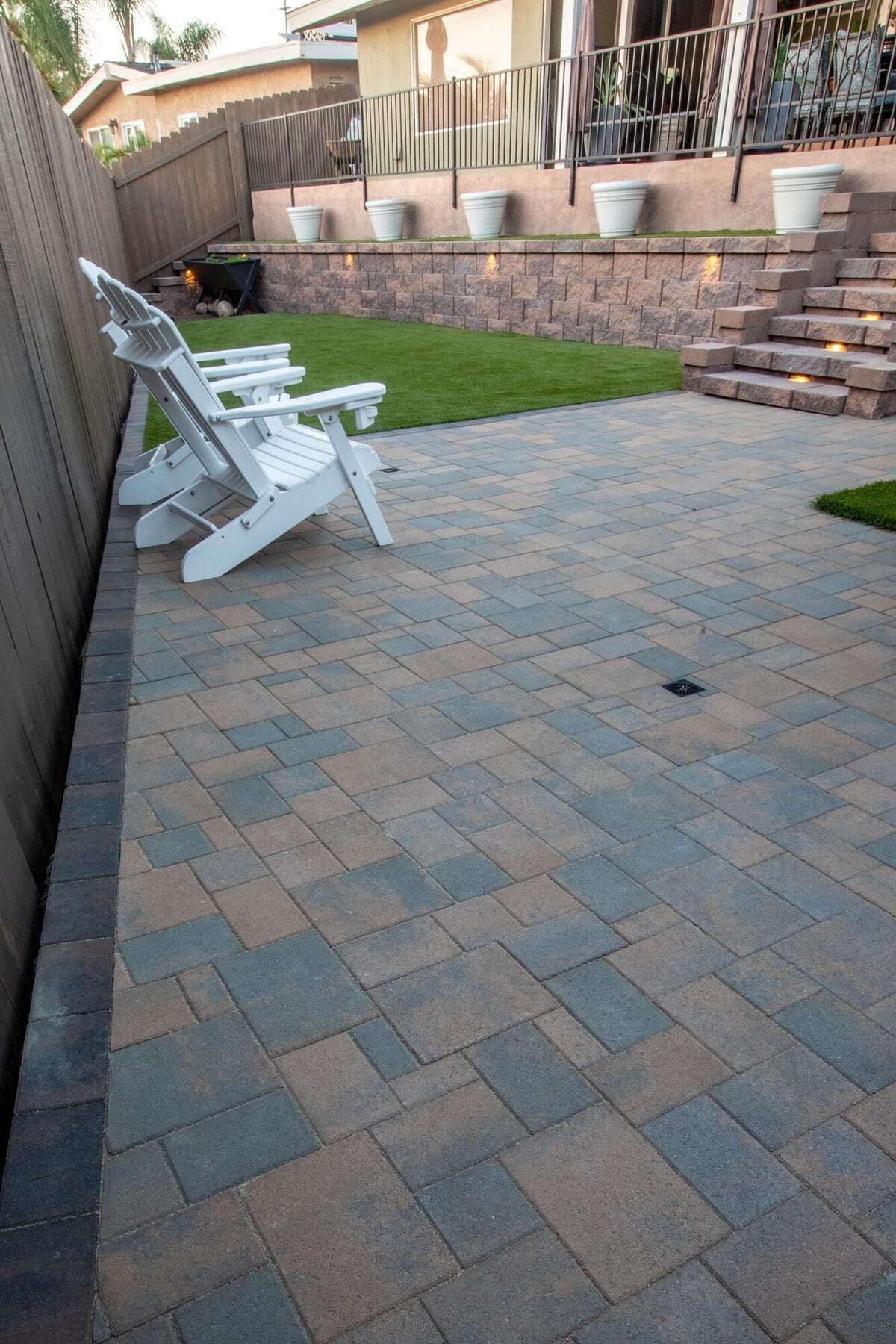 Multi-tone paver patio at the base of the block retaining wall