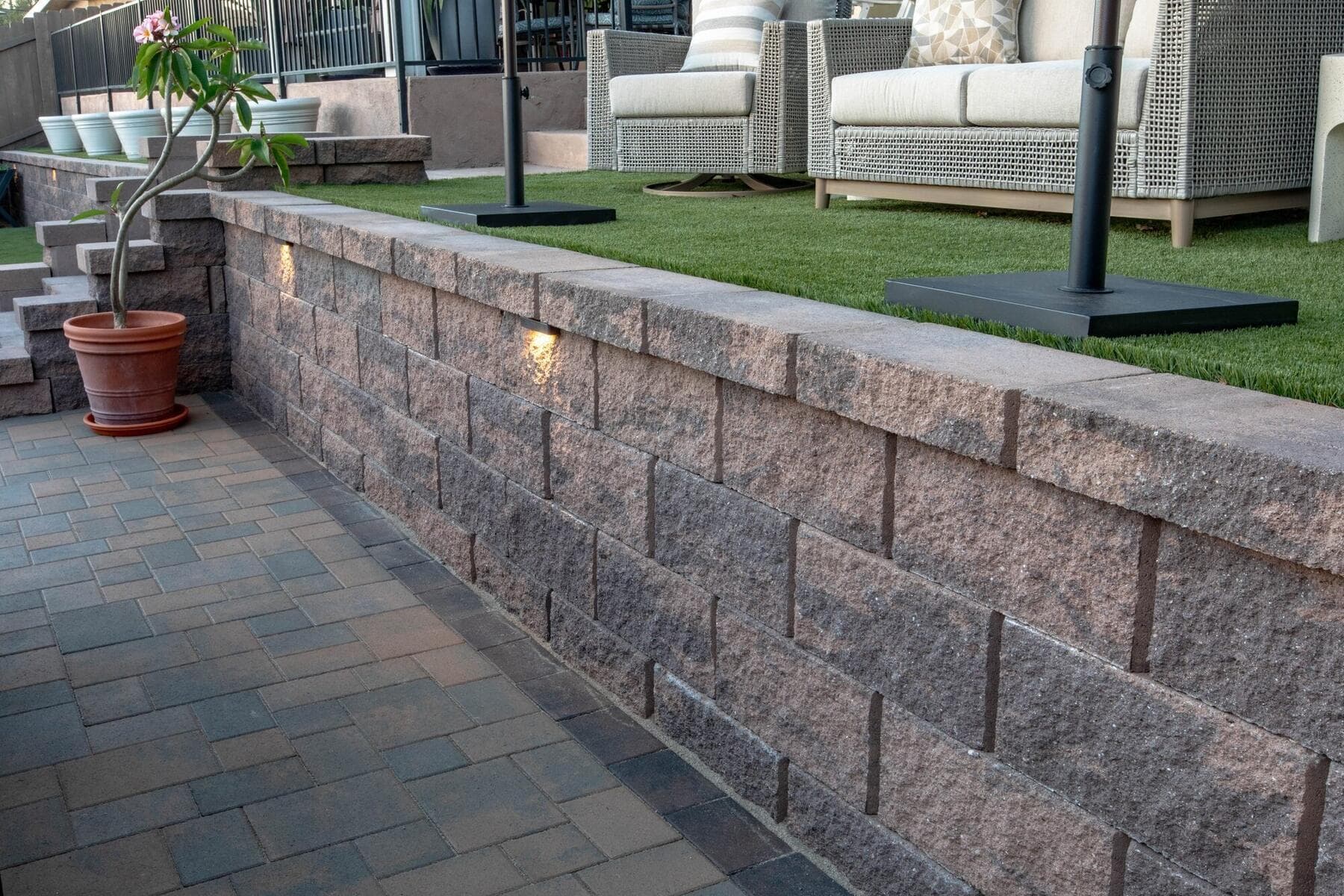Wall lights set into the block retaining wall above the turf
