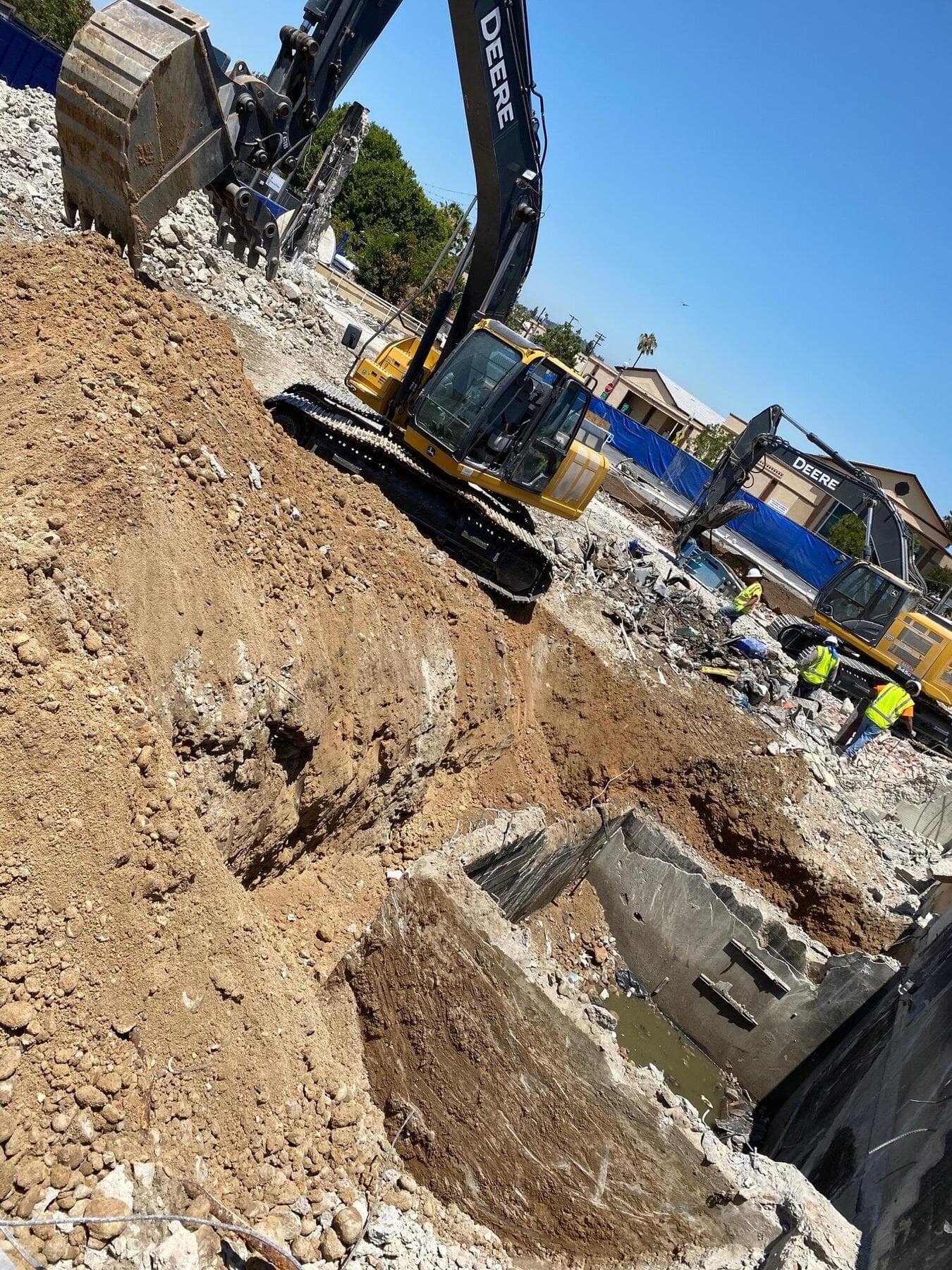 Deere excavators and crew on a commercial demolition in La Mesa