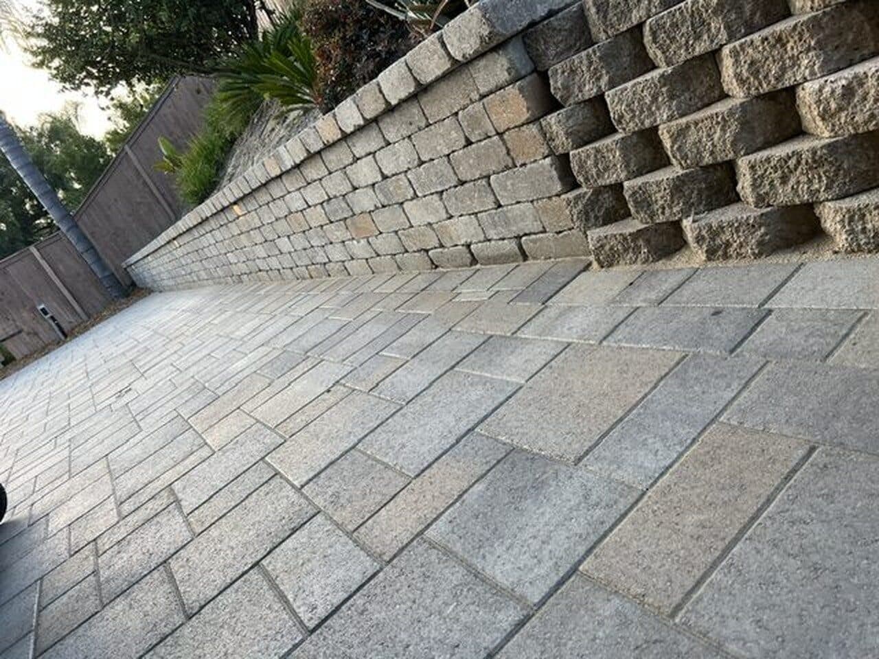 Block retaining wall running the length of the paver patio