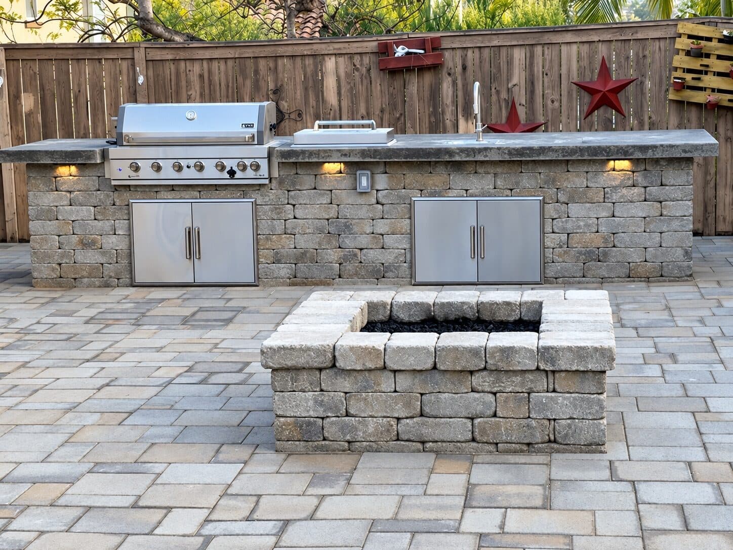 Block outdoor kitchen and firepit on a paver patio in Oceanside