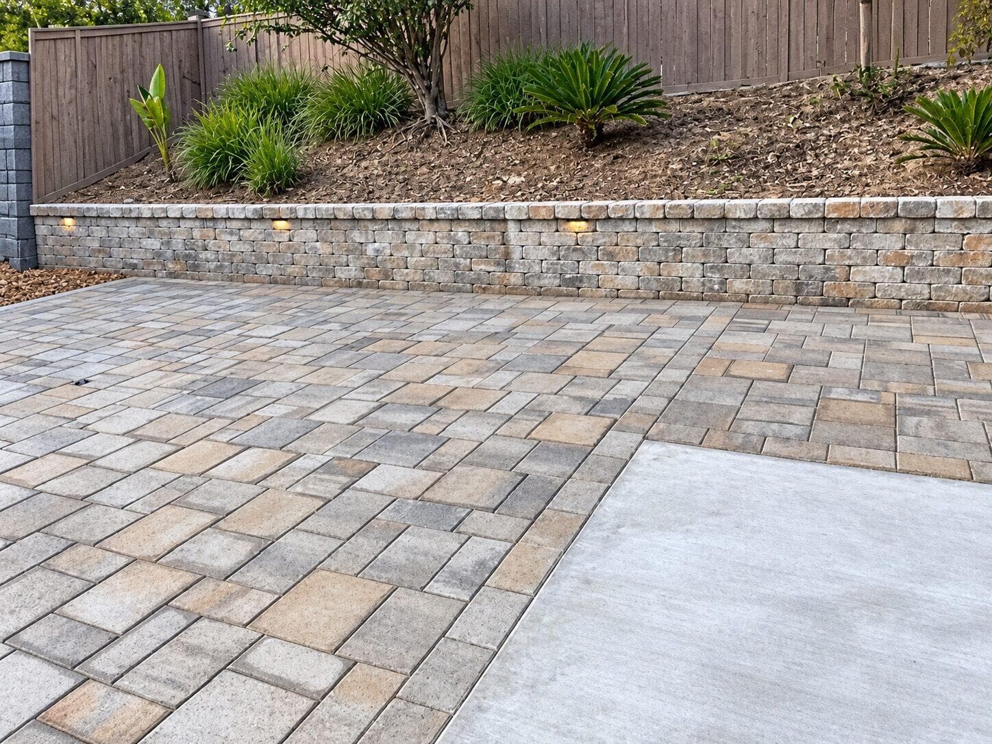 Paver patio and block retaining wall at the base of the slope