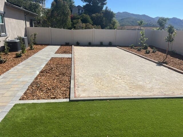 Decomposed-granite pad, turf, and paver walk in a new-home Poway backyard