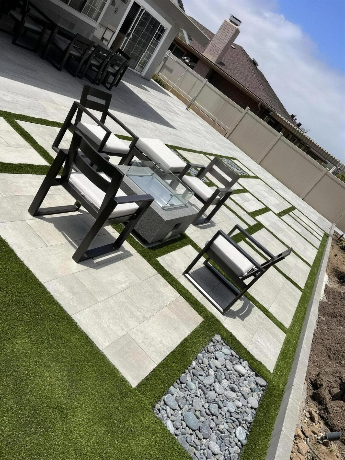 Lounge chairs around the fire table on Durafusion slabs with turf bands