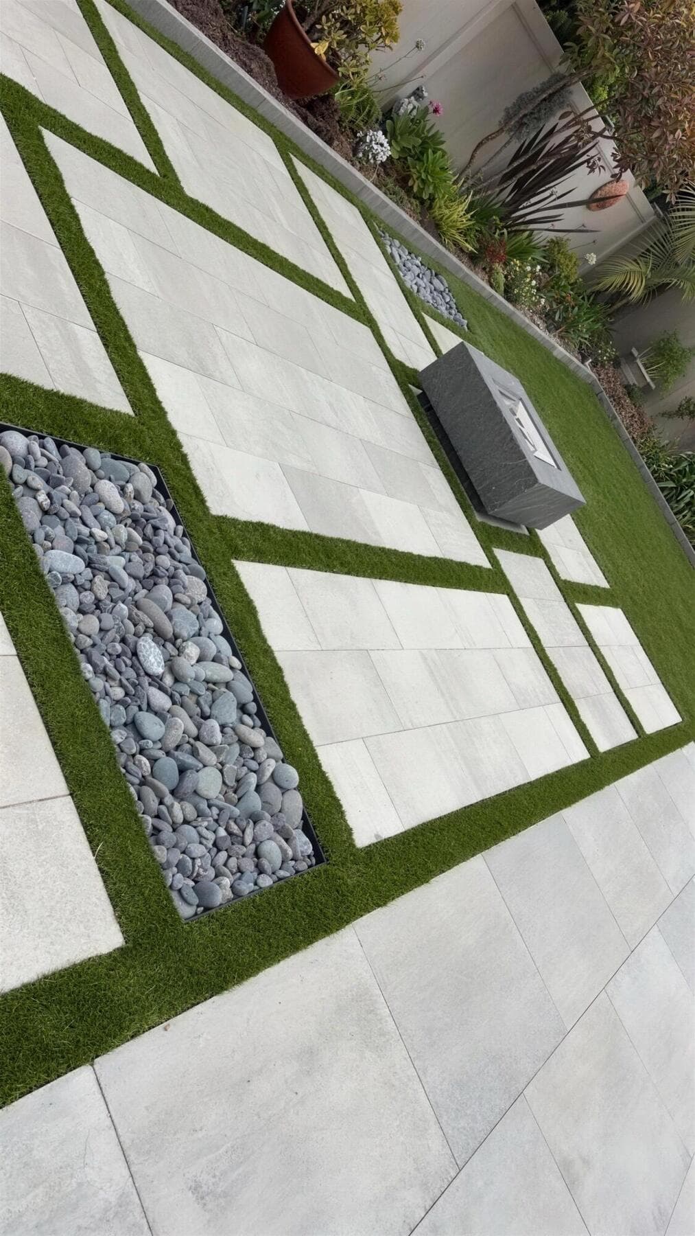 River-rock panel set in turf between large-format slabs