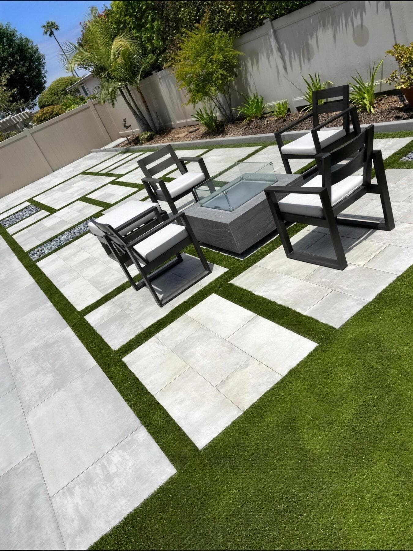 Seating area on slabs and turf looking toward the block wall and planting