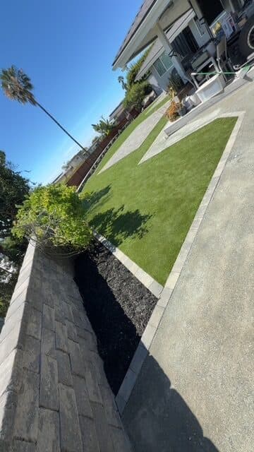Seating wall, planting bed, turf, and DG walk toward the house