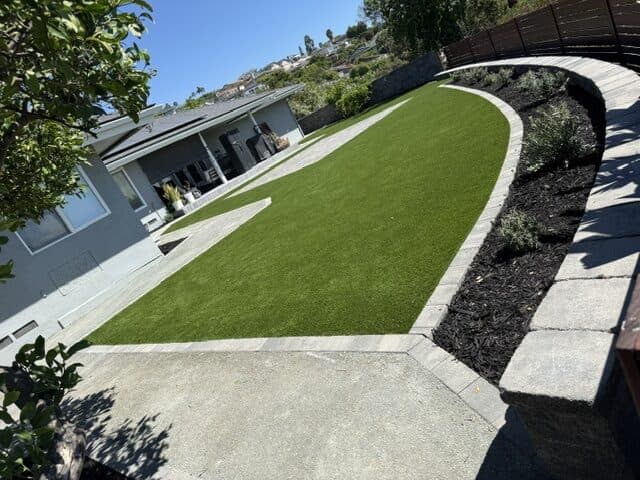 Turf lawn, curved seating wall, and DG walk along the house